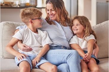 Mother sitting on sofa with young girl and boy