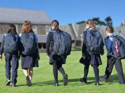 school children walking across yard to class