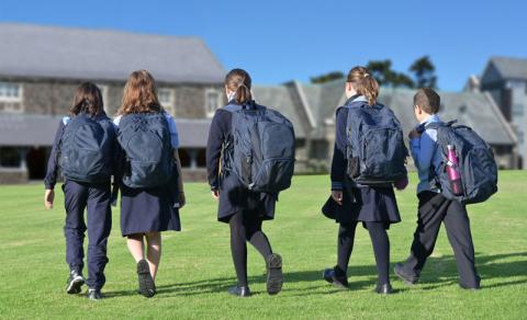 school children walking across yard to class